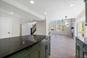 Kitchen featuring light hardwood / wood-style floors, hanging light fixtures, and a textured ceiling