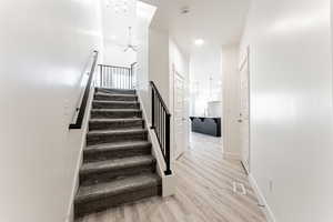 Stairway with ceiling fan, sink, and hardwood / wood-style floors