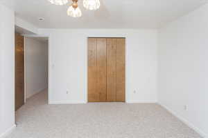 Unfurnished bedroom with ceiling fan, light carpet, and a closet