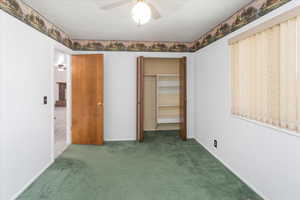 Unfurnished bedroom with a closet, carpet, and ceiling fan