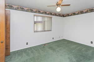 Spare room with ceiling fan and carpet