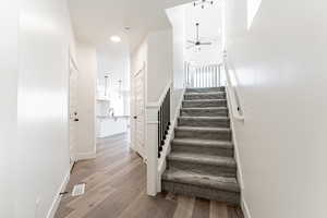 Stairway featuring hardwood / wood-style floors and ceiling fan