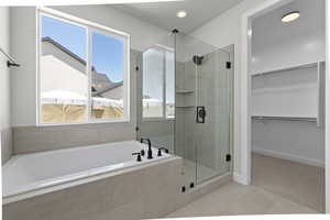 Bathroom featuring tile patterned flooring and separate shower and tub