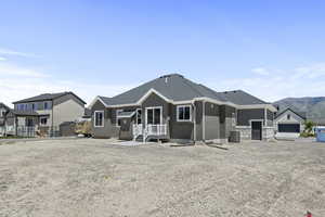 Rear view of house with a mountain view, central air condition unit, and a garage