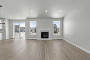 Unfurnished living room featuring a chandelier and light hardwood / wood-style floors