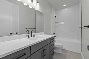 Full bathroom with tiled shower / bath combo, tile patterned flooring, vanity, and toilet