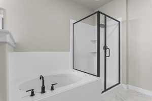 Bathroom featuring shower with separate bathtub