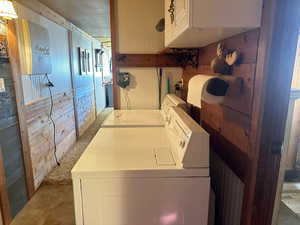 Laundry area featuring wood walls and washer and dryer