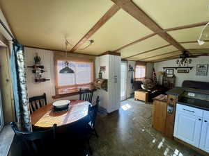 Dining space with vaulted ceiling with beams and ceiling fan