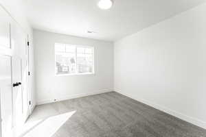 Unfurnished bedroom featuring a textured ceiling and light carpet