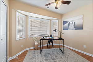 Office featuring hardwood / wood-style floors, ceiling fan, and a textured ceiling