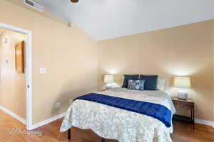 Bedroom featuring hardwood / wood-style flooring, ceiling fan, and vaulted ceiling