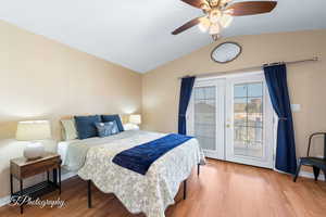 Bedroom featuring access to exterior, vaulted ceiling, light hardwood / wood-style flooring, and ceiling fan