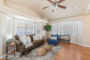 Living room with plenty of natural light, ceiling fan, light hardwood / wood-style flooring, and vaulted ceiling