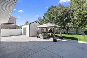 View of patio with a shed, a gazebo, and outdoor lounge area