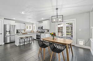 Dining space featuring a textured ceiling, a notable chandelier, and a wealth of natural light