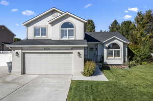 View of front facade with a front yard and a garage