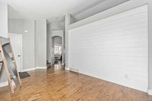 Empty room with lofted ceiling and hardwood / wood-style floors