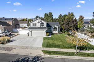 View of front facade featuring a garage, a mountain view, and a front yard