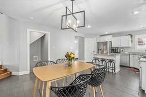 Dining room featuring an inviting chandelier, dark wood-type flooring, and a textured ceiling