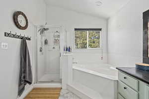 Bathroom with independent shower and bath, vanity, vaulted ceiling, and hardwood / wood-style flooring