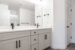 Bathroom with vanity, hardwood / wood-style floors, an enclosed shower, and a textured ceiling