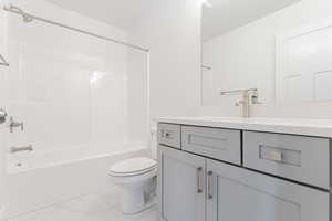 Full bathroom featuring toilet, vanity, and shower / washtub combination