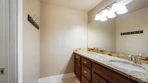 Bathroom featuring tile patterned flooring, baseboards, and vanity