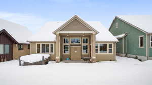 Snow covered rear of property with stucco siding