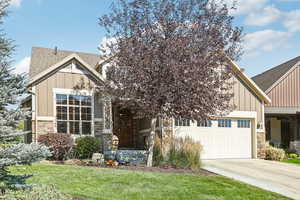 Craftsman-style house with a front yard and a garage