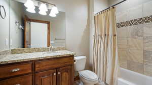 Full bathroom with shower / bath combo, vanity, and toilet