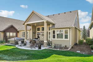 Back of house with a patio area, a lawn, a hot tub, and ceiling fan