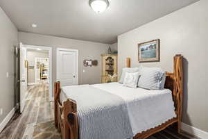 Bedroom with hardwood / wood-style flooring and a textured ceiling