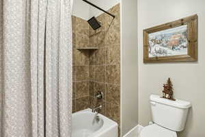 Bathroom with shower / tub combo and toilet