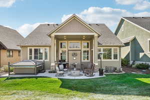 Back of house with a yard, a patio, and a hot tub