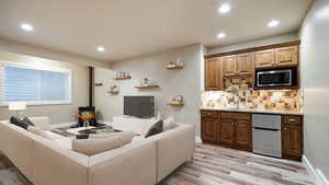 Living area featuring light wood-type flooring, a wood stove, baseboards, and recessed lighting