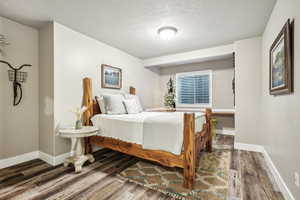 Bedroom featuring dark hardwood / wood-style floors and a textured ceiling