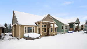 Snow covered property featuring stucco siding