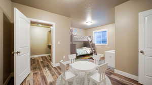 Bedroom featuring a textured ceiling, dark wood-type flooring, and baseboards