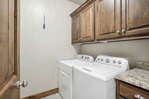 Washroom with cabinets and washer and dryer