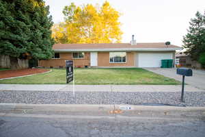 Ranch-style house featuring a garage and a front lawn