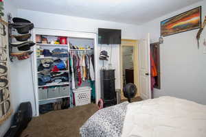 Carpeted bedroom with a closet