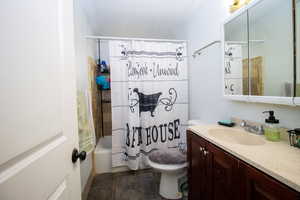 Full bathroom with shower / tub combo with curtain, vanity, toilet, and tile patterned flooring