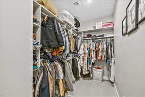 Walk in closet with light colored carpet