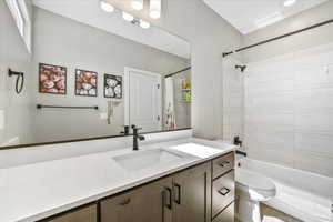 Full bathroom featuring shower / bath combination with curtain, vanity, and toilet