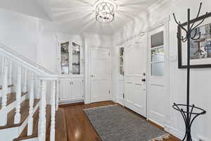 Front entry featuring original hardwood floors and original built-in cabinet