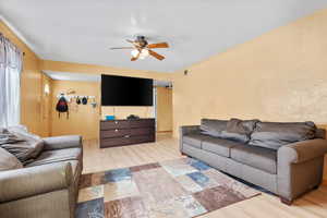 Living room featuring light wood-type flooring and ceiling fan