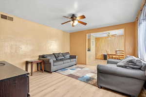 Living room featuring ceiling fan and light hardwood / wood-style flooring