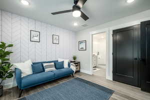 Living room with light wood-type flooring and ceiling fan