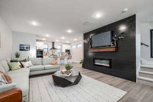 Living room featuring light wood-type flooring and a fireplace